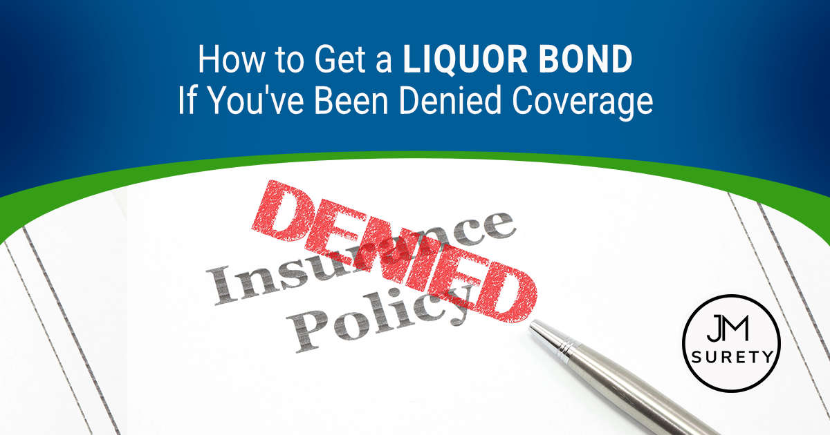 Insurance policy document with red 'DENIED' stamp overlay and a pen on white paper
